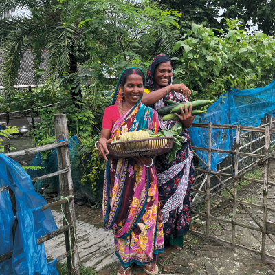 Molina Sana und Monjura Begum zeigen die Ernte aus ihren Gemüsegärten. Endlich gehören auch Obst und Gemüse zur alltäglichen Ernährung ihrer Familien.
