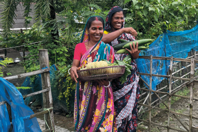 Molina Sana und Monjura Begum zeigen die Ernte aus ihren Gemüsegärten. Endlich gehören auch Obst und Gemüse zur alltäglichen Ernährung ihrer Familien.
